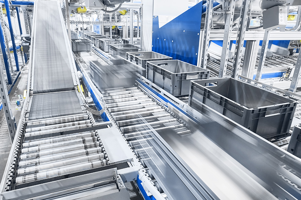 Modern conveyor system with boxes in motion, shallow depth of field.