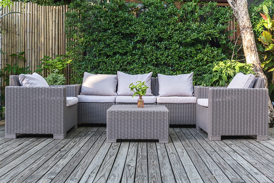 Large terrace patio with rattan garden furniture in the garden on wooden floor