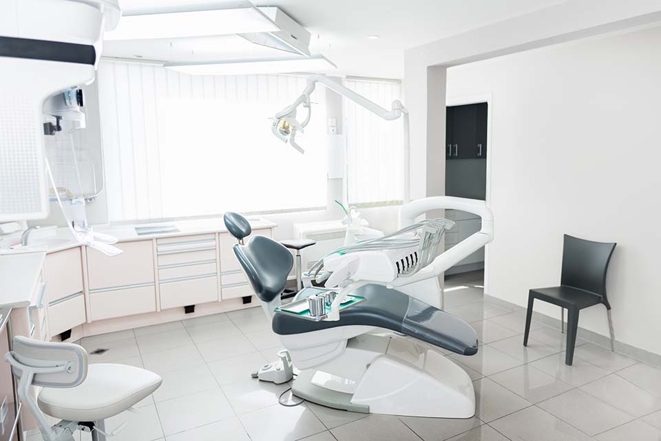 Practice room for a dentist with treatment chair, pull-out cupboards and ceiling floodlighting