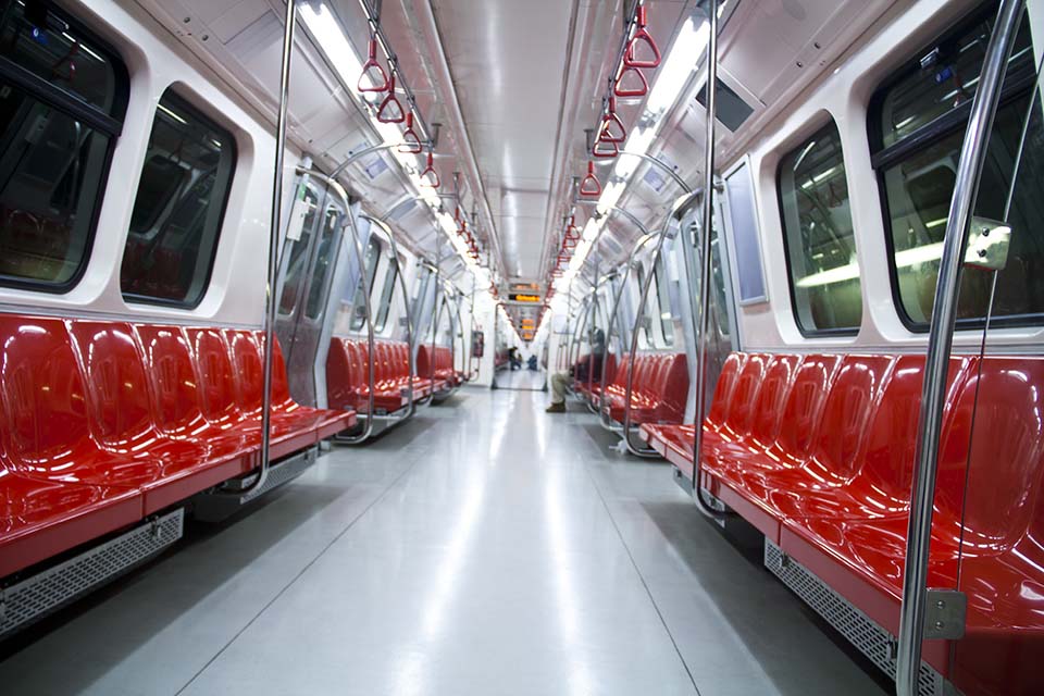 Empty underground compartment with sideways red seats and grey floor