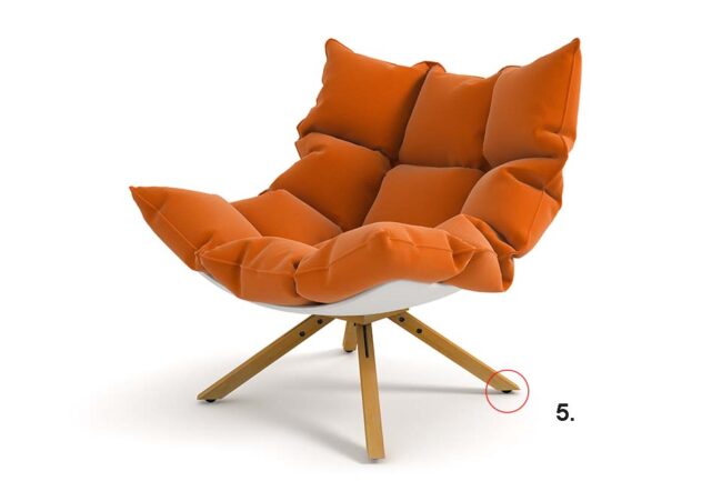 Moderner Sessel auf hohen Holzbeinen mit orangefarbener Polsterung und Bodenschonern