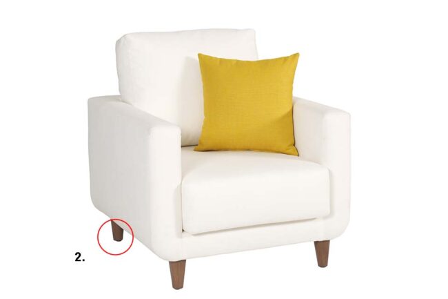 White upholstered living room armchair with yellow cushions and wooden legs on a white background