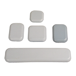 Das Foto zeigt eine Sammlung von rechteckigen Universalklebeplättchen. Sie bestehen aus grauem PTFE und sind selbstklebend.