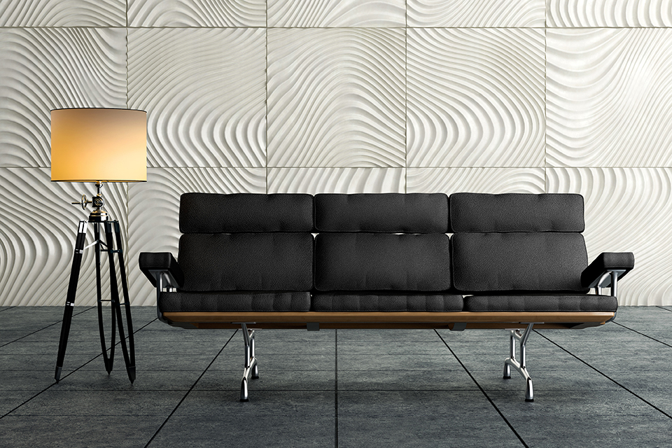 Ein modernes braunes Sofa und eine Stehlampe stehen auf dunkelgrau gefärbten, weichem und rauhem Naturstein