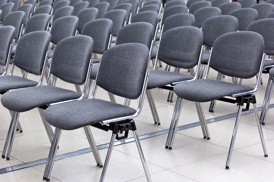 Stuhlreihen in einem Raum auf weichem glatten Naturstein stehend