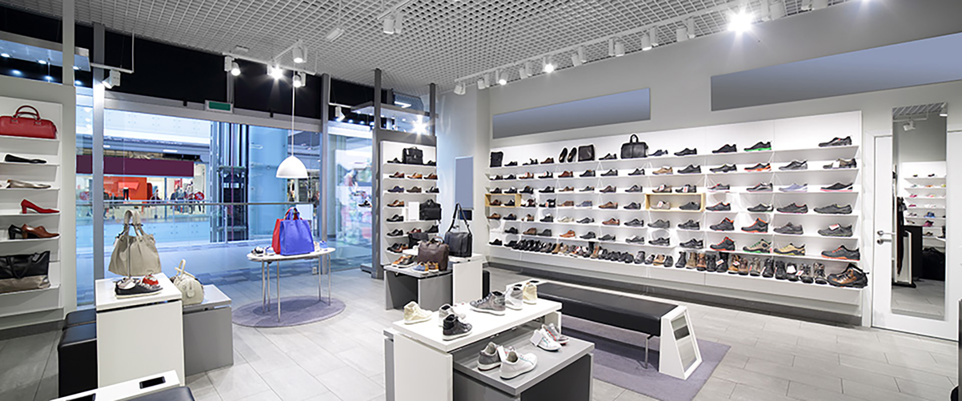 Ein helles und stilvolles Interieur eines Schuhgeschäfts in einem modernen Einkaufszentrum im Hintergrund eine große Fensterfront