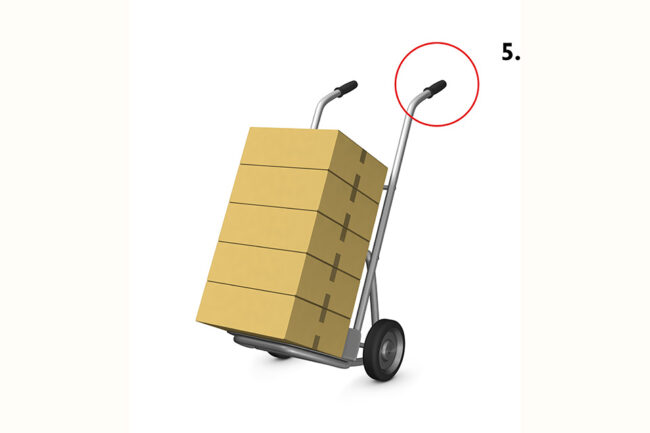 A side view of a handcart loaded with brown cardboard boxes. Isolated against a white background
