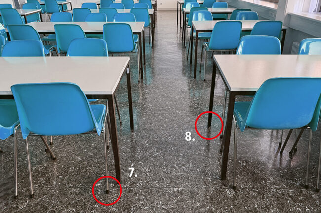Blue hard-shell chairs arranged around tables in a cafeteria